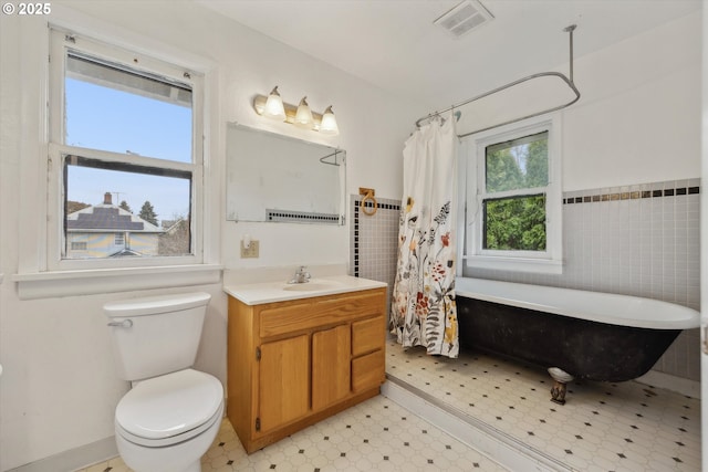 full bath featuring vanity, visible vents, a freestanding bath, tile patterned floors, and toilet