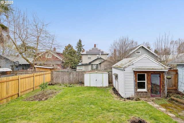 view of yard with an outbuilding, a shed, and a fenced backyard