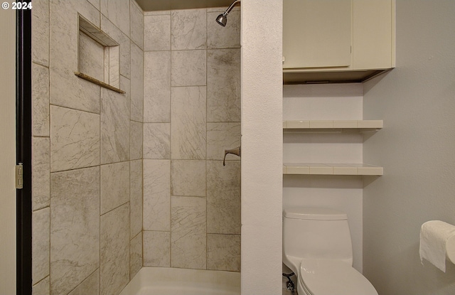 bathroom featuring toilet and a tile shower