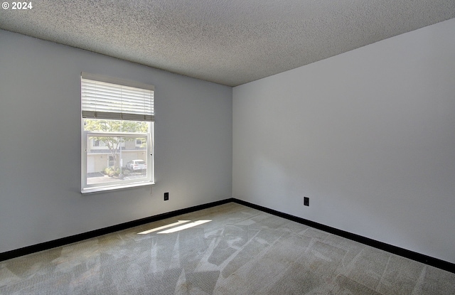 carpeted empty room with a textured ceiling