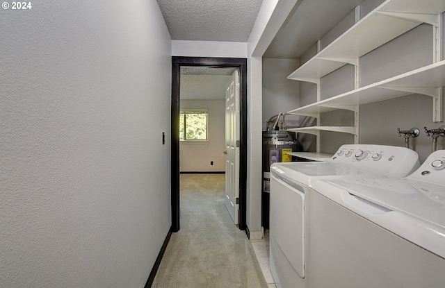 laundry room with light colored carpet, a textured ceiling, and separate washer and dryer