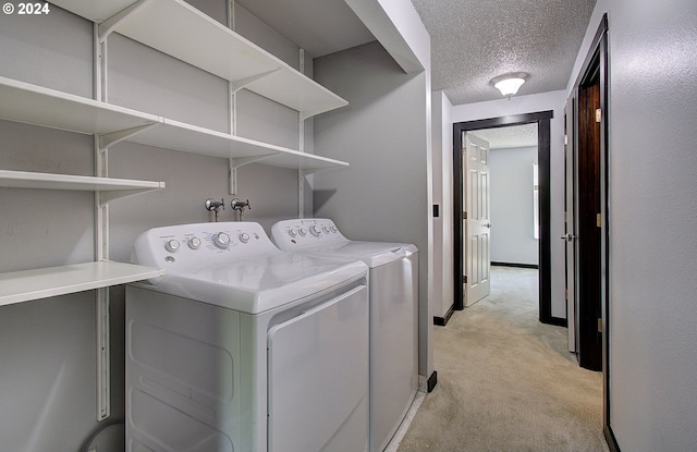 washroom featuring a textured ceiling, light carpet, and independent washer and dryer