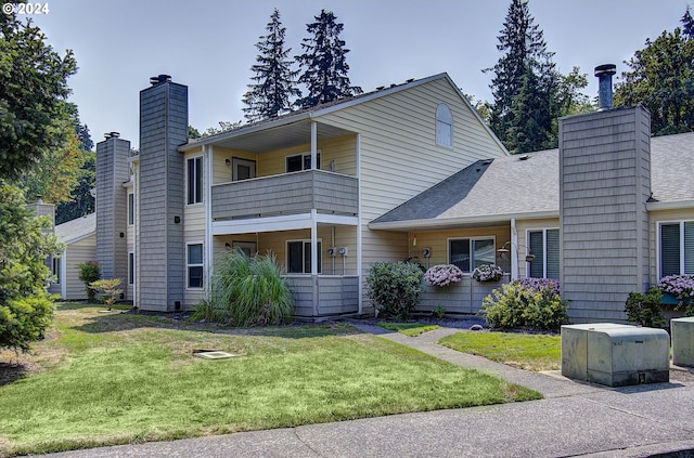 view of front facade featuring a front lawn and a balcony