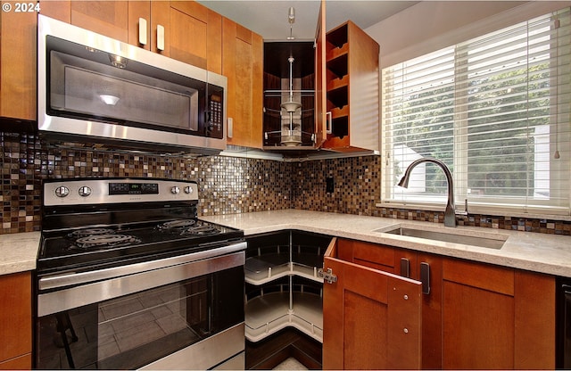 kitchen with sink, stainless steel appliances, light stone countertops, and tasteful backsplash