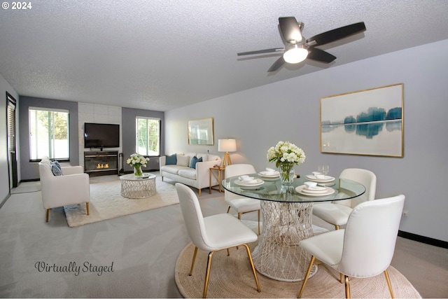 carpeted dining room featuring a wealth of natural light, a textured ceiling, and a fireplace