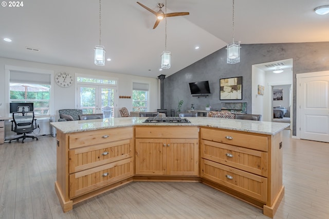 kitchen with tasteful backsplash, vaulted ceiling, a kitchen island, light hardwood / wood-style flooring, and appliances with stainless steel finishes