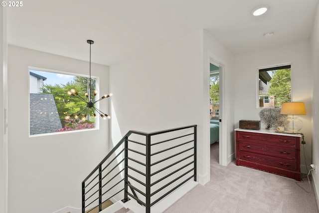 6332 NE 30th Ave, Portland, OR 97211 - hallway with an upstairs landing, a chandelier, light colored carpet, and baseboards