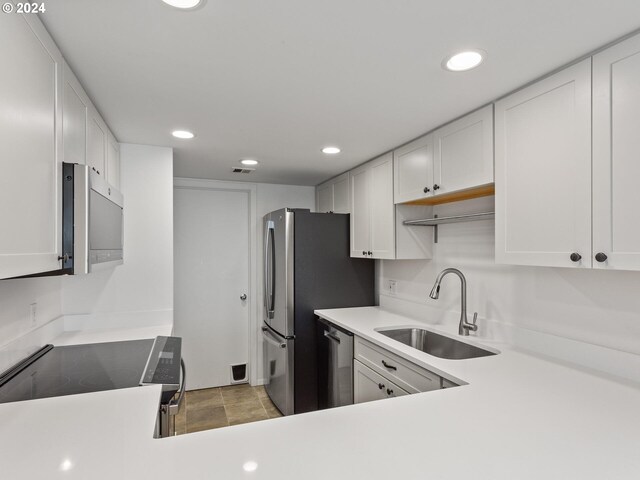 6665 W Burnside Rd Unit 413, Portland, OR 97210 - kitchen with electric stove, stainless steel dishwasher, light countertops, white cabinets, and recessed lighting