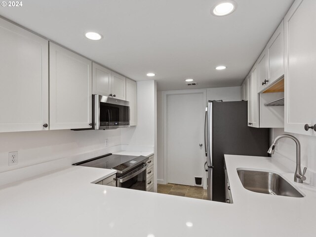 kitchen featuring white cabinets, light tile patterned floors, and stainless steel appliances