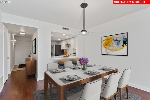 dining area with sink and dark wood-type flooring