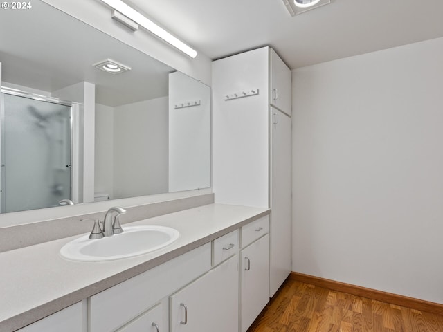 bathroom featuring toilet, vanity, hardwood / wood-style floors, and an enclosed shower