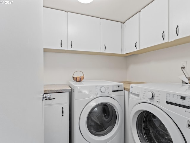 washroom featuring cabinets and washing machine and clothes dryer