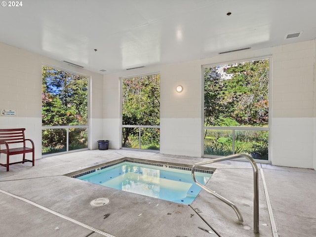 view of swimming pool featuring a patio area and an indoor in ground hot tub