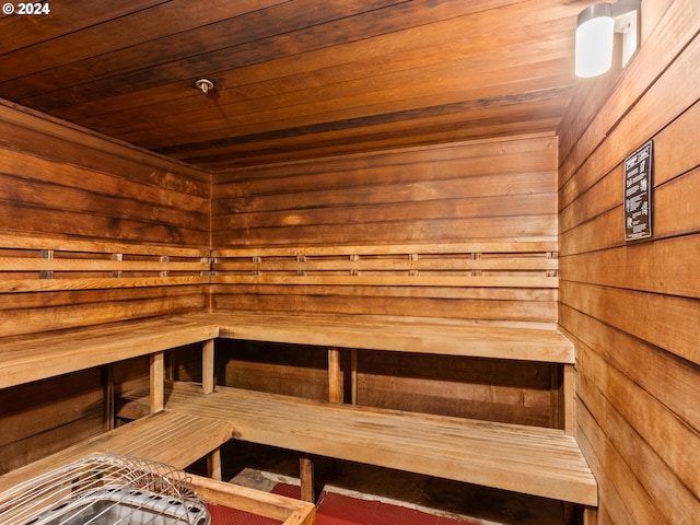 view of sauna featuring wood ceiling and wood walls