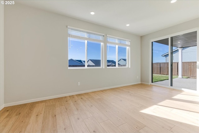 empty room featuring light wood-type flooring and a healthy amount of sunlight