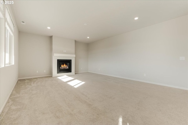 unfurnished living room featuring a healthy amount of sunlight and light colored carpet