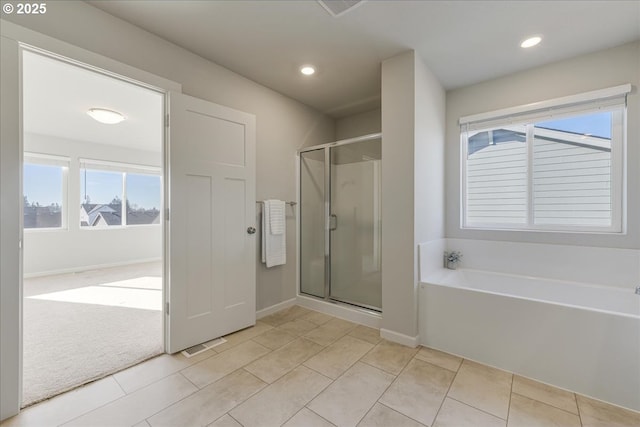 bathroom featuring a healthy amount of sunlight, tile patterned floors, and separate shower and tub