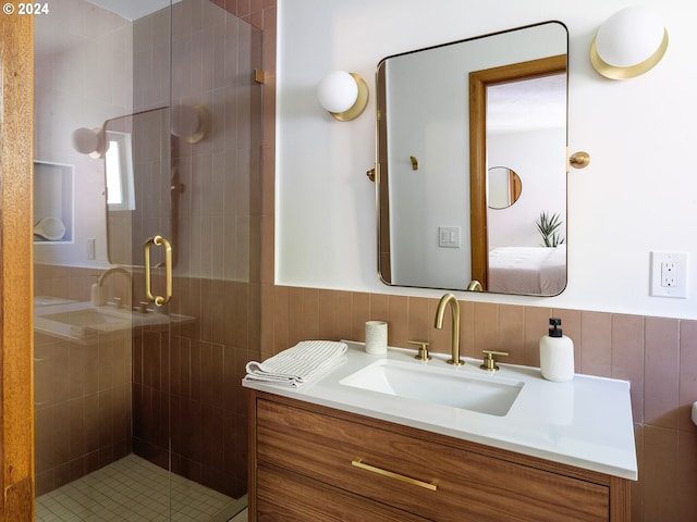 bathroom with a shower with shower door and vanity