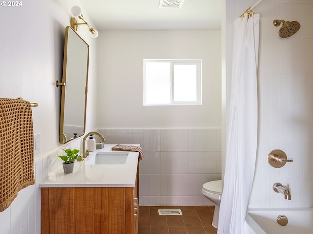 full bathroom featuring vanity, toilet, shower / bath combo with shower curtain, tile walls, and tile patterned flooring