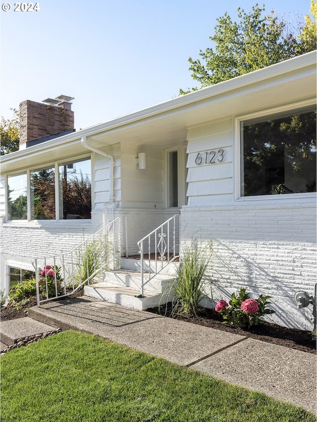 doorway to property with a lawn