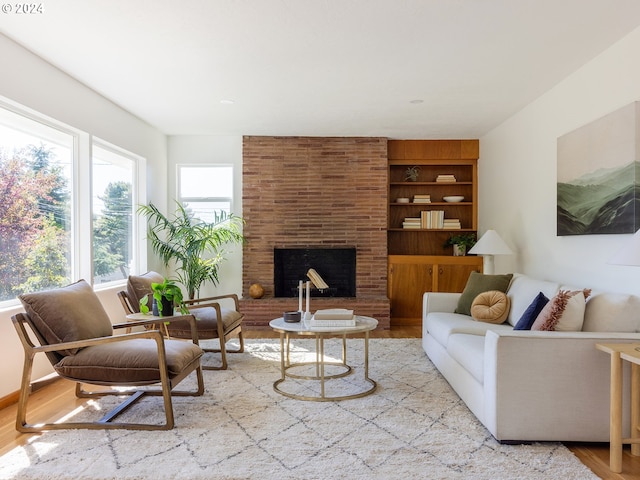 living room with a brick fireplace and light hardwood / wood-style floors