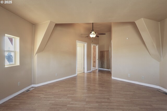 bonus room with wood-type flooring, vaulted ceiling, and ceiling fan