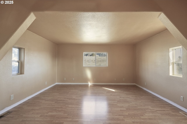 empty room with light hardwood / wood-style flooring and a textured ceiling