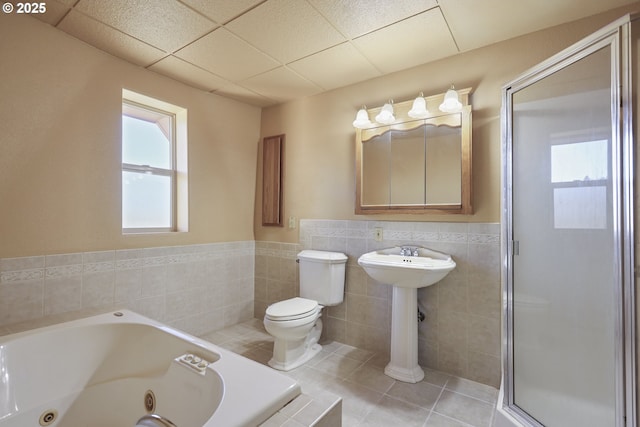 bathroom with tile patterned flooring, plus walk in shower, toilet, tile walls, and a paneled ceiling