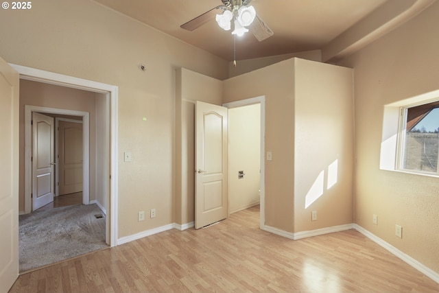 unfurnished bedroom featuring lofted ceiling and light hardwood / wood-style floors