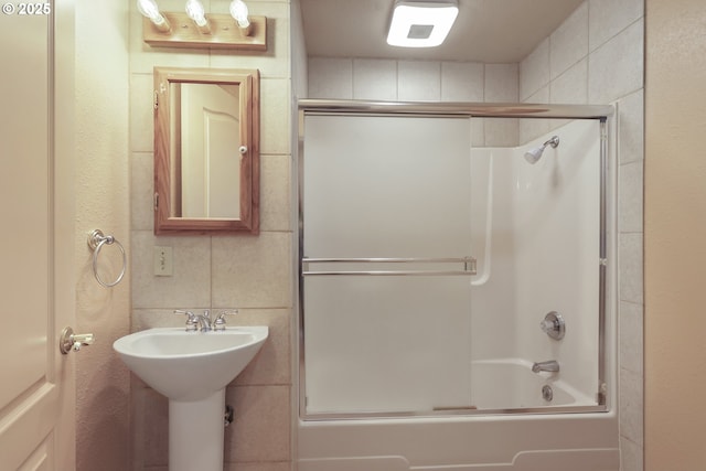 bathroom featuring sink and combined bath / shower with glass door