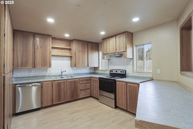 kitchen featuring appliances with stainless steel finishes, sink, light hardwood / wood-style floors, and decorative backsplash