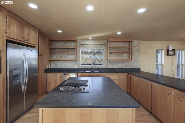 kitchen featuring sink, backsplash, light hardwood / wood-style flooring, and stainless steel appliances