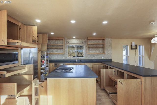 kitchen featuring light hardwood / wood-style flooring, appliances with stainless steel finishes, backsplash, light brown cabinetry, and kitchen peninsula