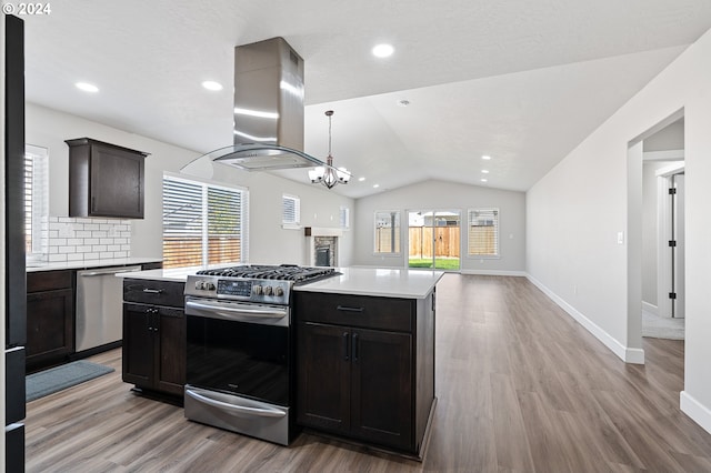 kitchen featuring stainless steel appliances, a wealth of natural light, lofted ceiling, and island range hood