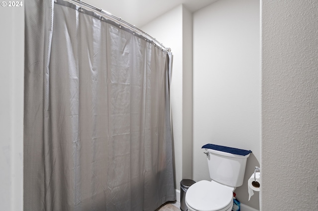 bathroom featuring curtained shower and toilet