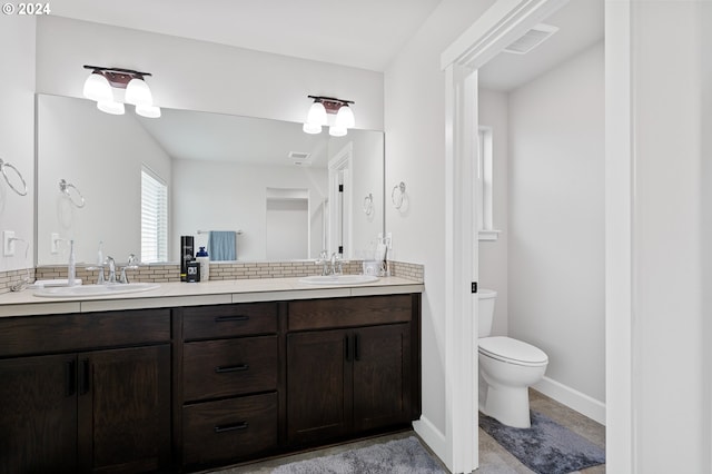 bathroom featuring vanity, toilet, and tasteful backsplash