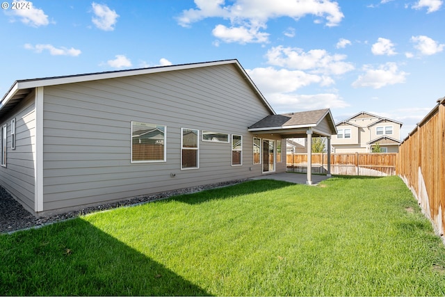 back of property with a yard and a patio