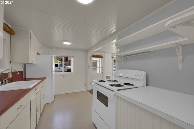 kitchen featuring sink, white appliances, and white cabinetry