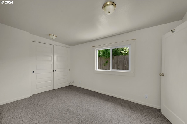 carpeted empty room featuring vaulted ceiling