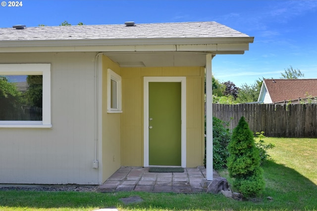 property entrance featuring a lawn