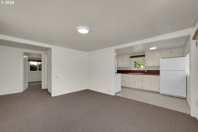 kitchen with light colored carpet, white fridge, sink, and white cabinetry