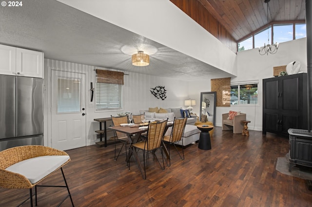 dining area with a healthy amount of sunlight, dark wood-type flooring, and a wood stove