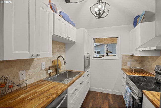 kitchen with stainless steel appliances, white cabinets, wooden counters, and sink