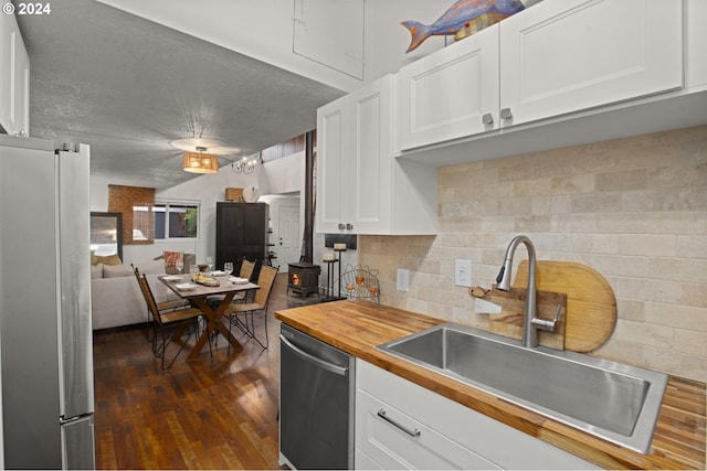 kitchen featuring stainless steel appliances, butcher block counters, dark hardwood / wood-style flooring, white cabinets, and sink