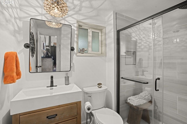 bathroom with walk in shower, vanity, and toilet