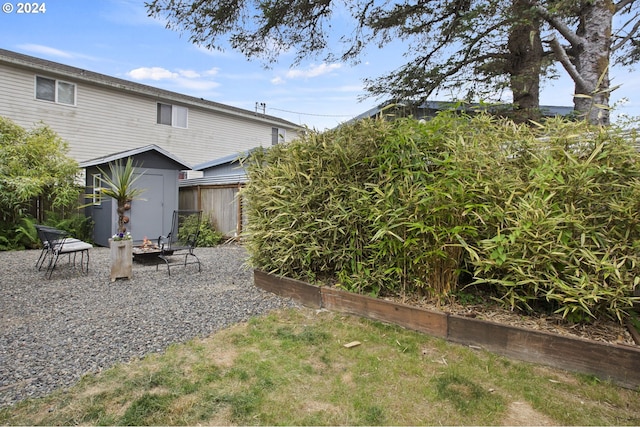 view of yard with a fire pit and a storage shed