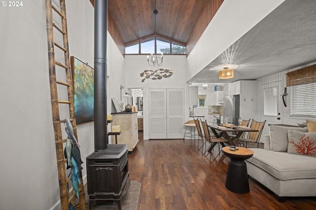 entrance foyer with wooden ceiling, an inviting chandelier, vaulted ceiling, a wood stove, and dark wood-type flooring