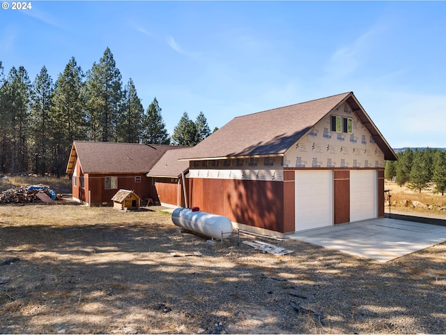 view of front of house featuring a garage and an outbuilding