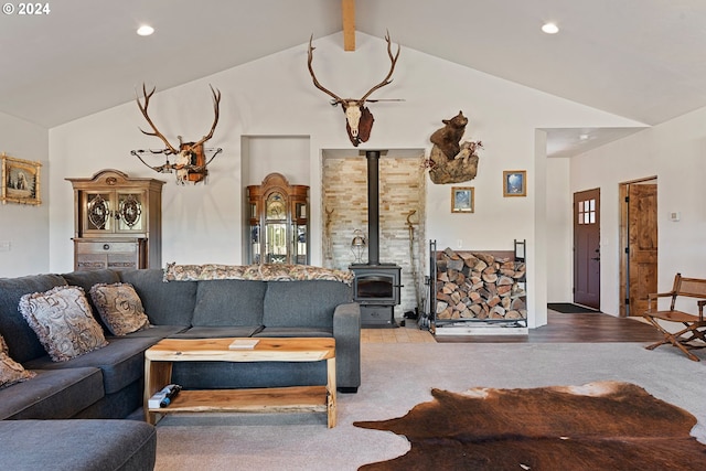 living room featuring a wood stove, vaulted ceiling with beams, and hardwood / wood-style flooring