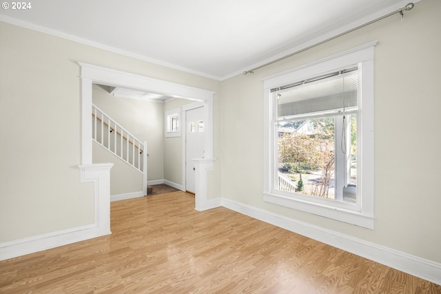 empty room with light hardwood / wood-style floors and ornamental molding